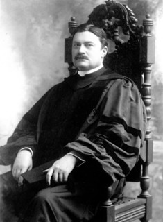 Charles Burch seated in academic robe