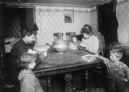 Picking nuts in dirty basement, December 1911 Picking nuts in dirty basement. The dirtiest imaginable children were pawing over the nuts eating lunch on the table