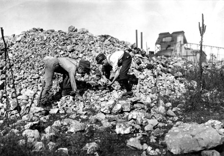 Two young boys collecting rocks, 1912