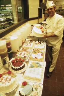 German Immigrant Hans Strzyso Is the Chief Baker at Madsens Supermarket. He Specializes in All Types of Decorated Cakes and Ethnic German Baked Goods Which Are Made Fresh Daily ca. 1975