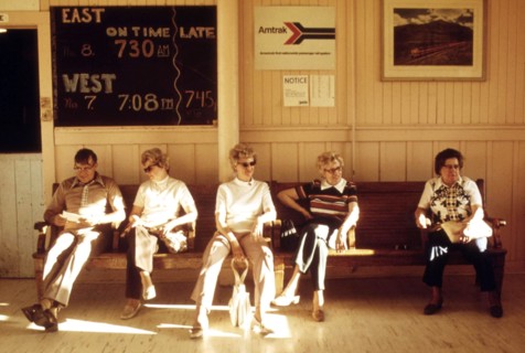 Passengers waiting in the station at East Glacier Park Montana, for the train which will take them to Seattle, Washington, June 1974