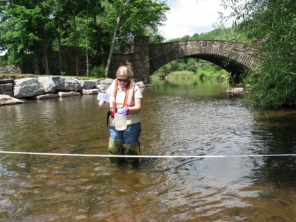 USGS hydrologist collecting a water quality sample from a NY stream ca. June 2010