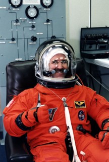 STS-81 Mission Specialist John M. Grunsfeld. gives a thumbs-up as he completes his launch/entry suitup in the Operations and Checkout (O&C) Building ca. 1997