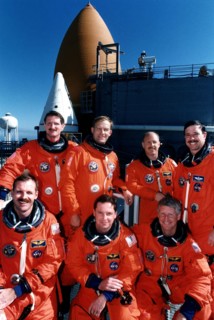 STS-82 crew members are all smiles as they pose for a group photo at Launch Pad 39A in front of the Space Shuttle Discovery ca. 1997