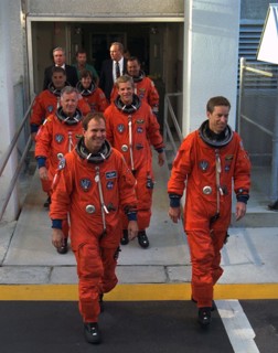 STS-86 Commander James Wetherbee, in foreground at right, leads the way as the next Space Shuttle crew does a practice walkout from the Operations and Checkout Building ca. 1997