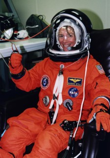 STS-83 Pilot Susan Still gives a thumbs-up as she is assisted into her launch/entry suit in the Operations and checkout (O&C) Building ca. 1997
