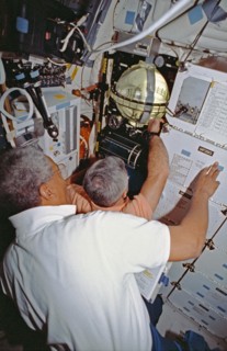 Crewmembers in the middeck with the FARE experiment.