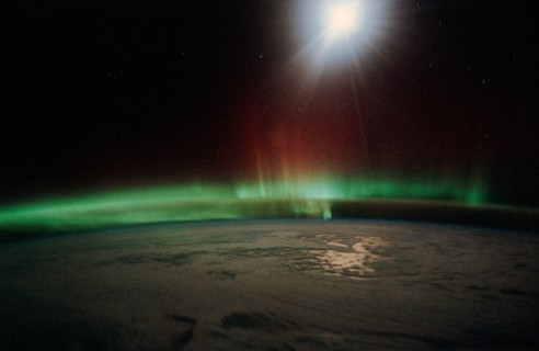 1991 - Moonlight saturates the high speed film used for auroral photography. Moon glint is visible in the open ocean and the cloud patterns are well illuminated. This frame was taken with a handheld 3...