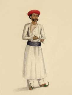 Hindu man stands in white tunic over white trousers