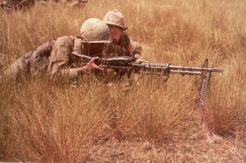 Men of the 1st Inf Div draw sniper fire while on a search and destroy mission. Bien Hoa, Vietnam, 10/65.