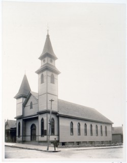 African American man standing on sidewalk in front of church c. 1900