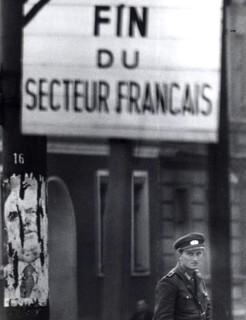 Officer Of East German Peoples Police Stands Guard At Control Point At Brunnenstarsse, A Workers