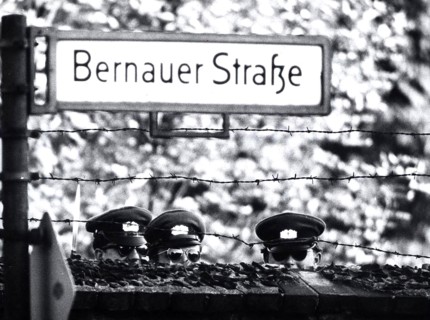 Three Communist 'VOLPO's', East German Police, Stretch to Get a Look Over a Cemetery Wall Which
