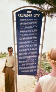 Tourists reading a sign in Caesarea about 'The Crusader City.'