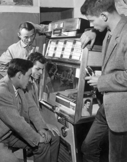 jeunes gens autour d'un juke box écoutant un disque, 1960