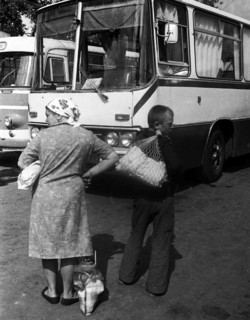Villagers middle-aged woman and a boy at the bus station before the buses.