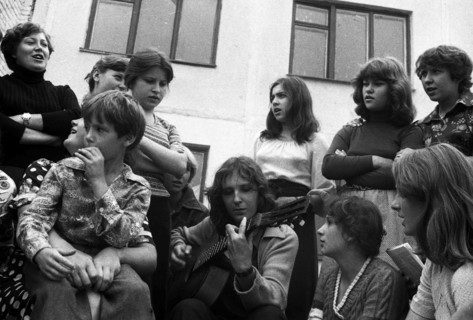 Youth with a guitar sings in the school yard.