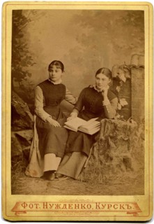 Two girls with a book in her lap.