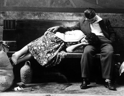Couple on a bench in the central station of Milan, Italy 60's