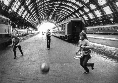 Three teen playing football at central station in milan, 70's