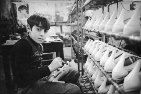 Little boy working in a shoes manufacturing, naples, italy, 70's