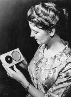 A woman with a powered by solar energy portable radio, 1957