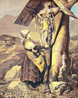 Woman in front of a field cross in the Alps