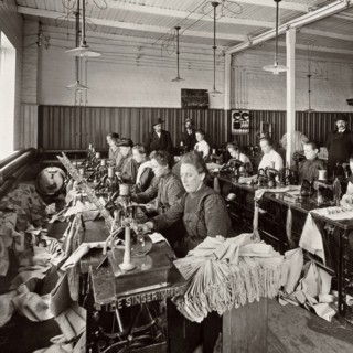 Women sewing at a sewing workshop of the Singer Society circa 1904