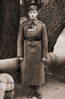 Tsarevich Alexei Nikolaevich of Russia in a Military uniform in front of a cannon