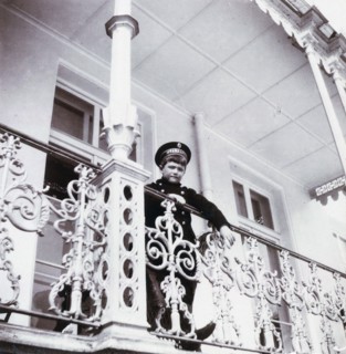 Tsarevich Alexei Nikolaievich of Russia stands on the banister of Alexander Palace's Balcony