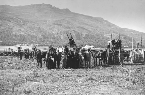 A large group of people standing with their horses and carriages.