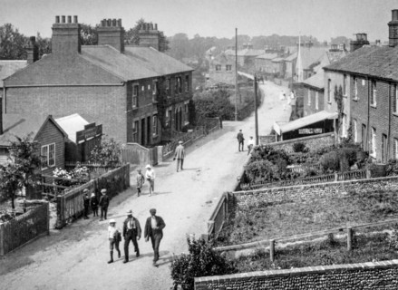 A typical street scene around 1910 with little boys in the street wearing flat caps.