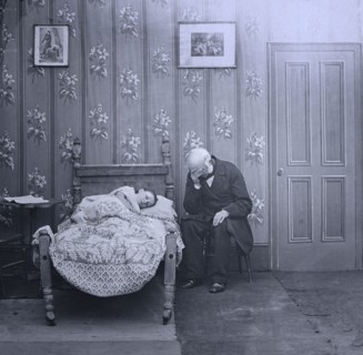 Jessica lies ill on bed with a vicar sitting next to her.