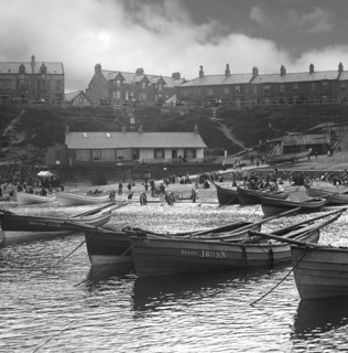 Cullercoats Bay with coble fishing boats and people on the beach.