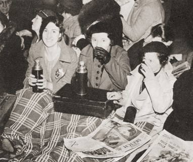 Three women have an early morning cup of tea in Piccadilly Circus.