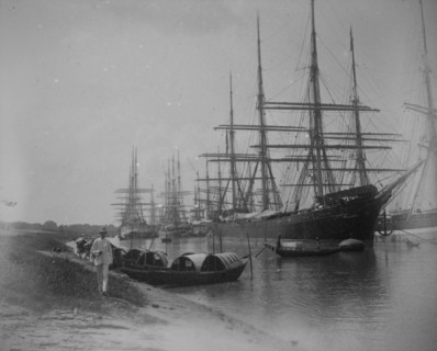 Sampans and sailing ships moored on a river inlet in Calcutta