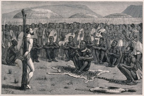 Ernest Grandier, a Zulu prisoner, stands naked and tied to a stake in front of the tribe and awaits
