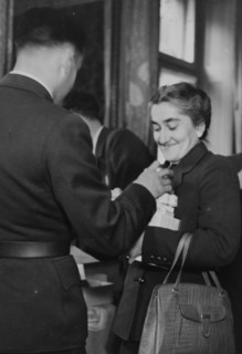A nurse receiving her emergency ration: chocolate, Ovomaltine, tinned food, soup cubes, crispbread