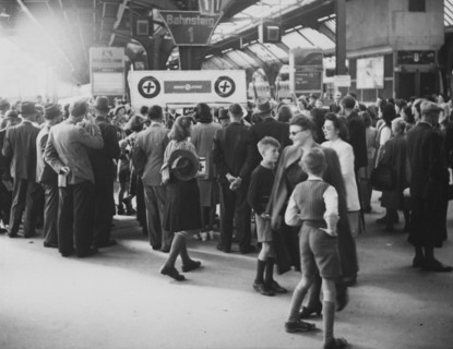 People gather around a stand of Swiss Aid after the war around 1945.