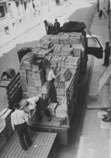 Men unloading truck; fruits in case; 1945.