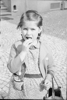 Girl eating chocolate; around 1943.