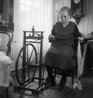 Woman sitting at spinning wheel 1946 .