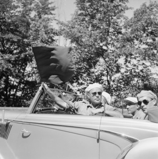 Carl Senn, race director Tour of Switzerland 1952 in a car with flag