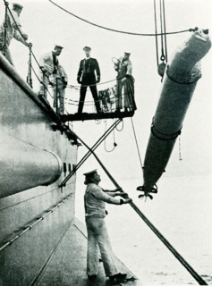This photo from world war I shows a practice torpedo being hoisted over the side of a British ship.