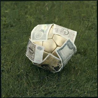 Golden football, having banknotes stuck all over