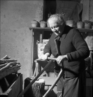 Old woman sawing firewood, 1954