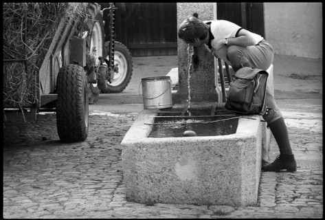 Hiker drinking water at a fountain, Switzerland 1971