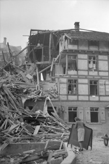WW 2: bomb airdrop, dropping. woman in front of destroyed house, Schaffhausen 1944