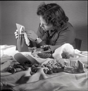 Woman making a Santa Claus doll in 1944.