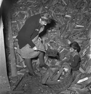 Woman finding lost army shovel in firewood storeroom 1949.